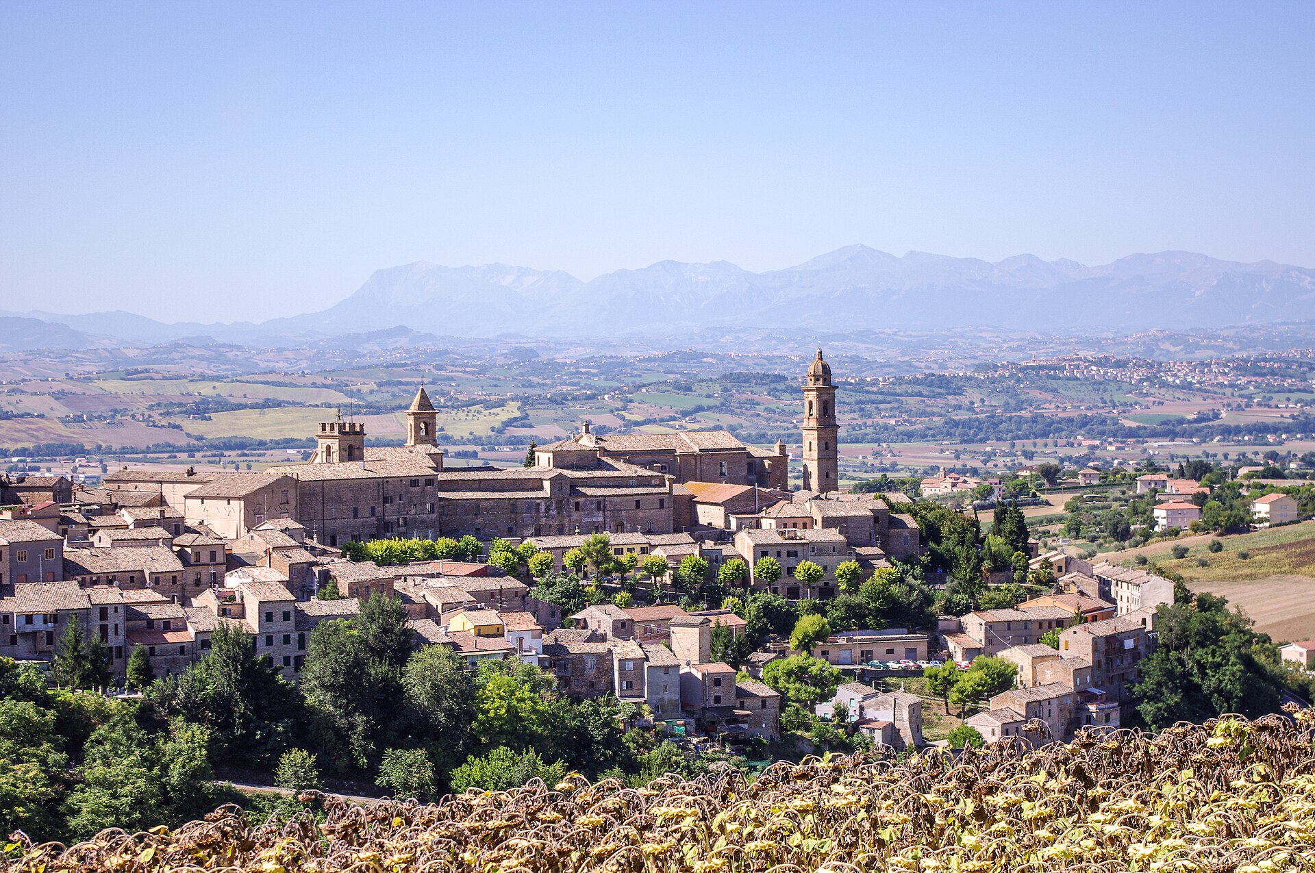 Un borgo sul crinale delle colline maceratesi con i Monti Sibillini sullo sfondo