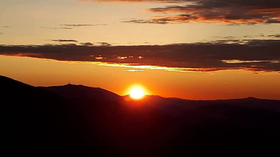 Il sole che tramonta dietro il profilo dei Monti Sibillini
